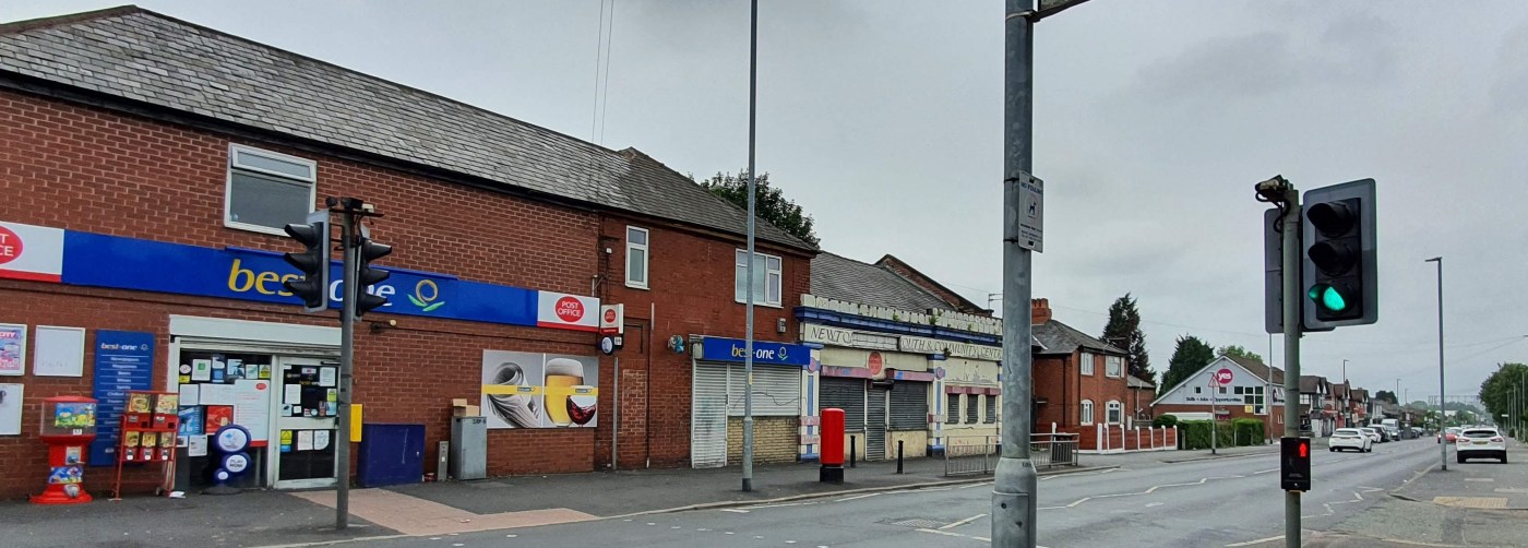 A main road with a post office in a local convenience store next to a dilapidated community centre